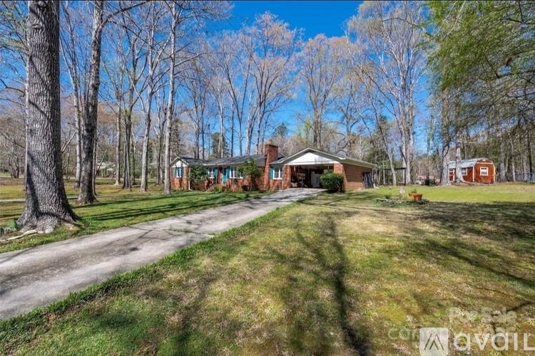 A house with a driveway and trees in the background.