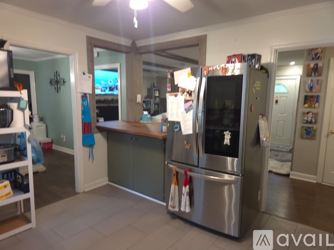 A kitchen with a stainless steel refrigerator and a ceiling fan.