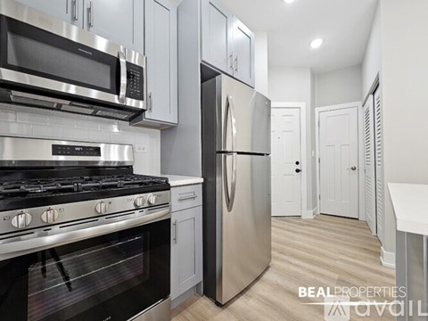 A modern kitchen with stainless steel appliances and white cabinets.