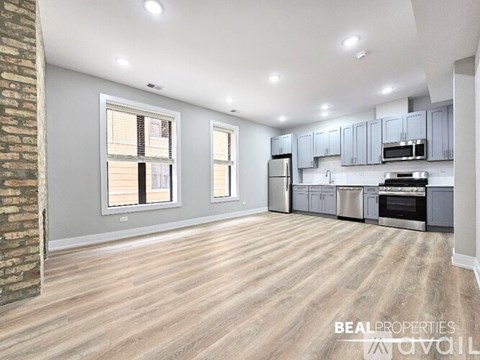 A spacious kitchen with wooden flooring and modern appliances.