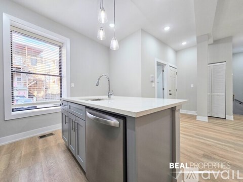A modern kitchen with a large island and stainless steel appliances.