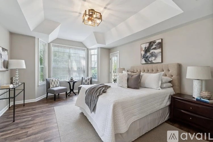 A bedroom with a large bed and a chandelier.