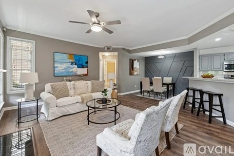 A living room with a white couch, a coffee table, and a painting on the wall.