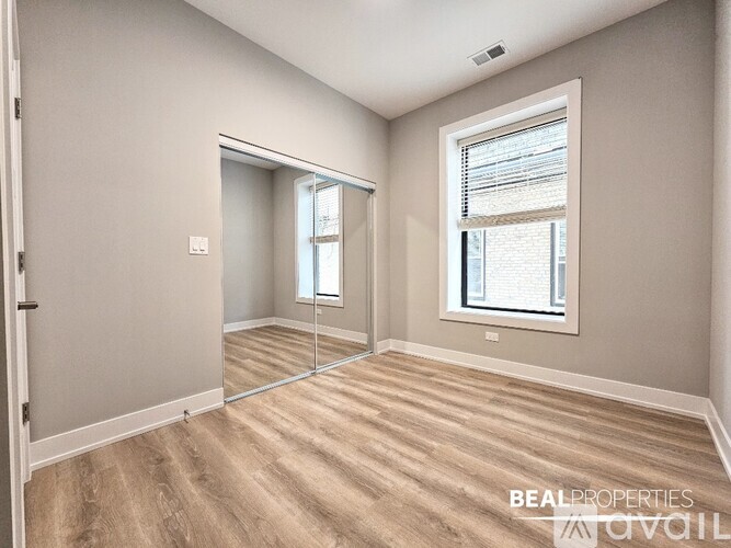 A spacious room with a large window and a sliding glass door.