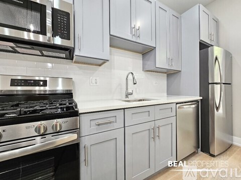 A modern kitchen with a stainless steel refrigerator and a stove top oven.