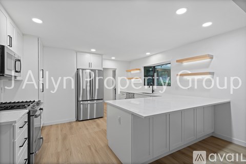 A modern kitchen with white cabinets and a central island.