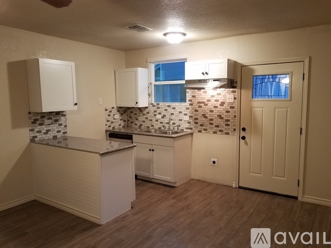 A kitchen with white cabinets and a tiled backsplash.