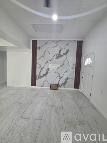 A room with a marble wall and wooden trim.