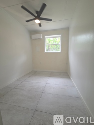 A room with a ceiling fan and a window.