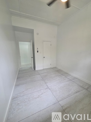 A room with a tiled floor and a ceiling fan.