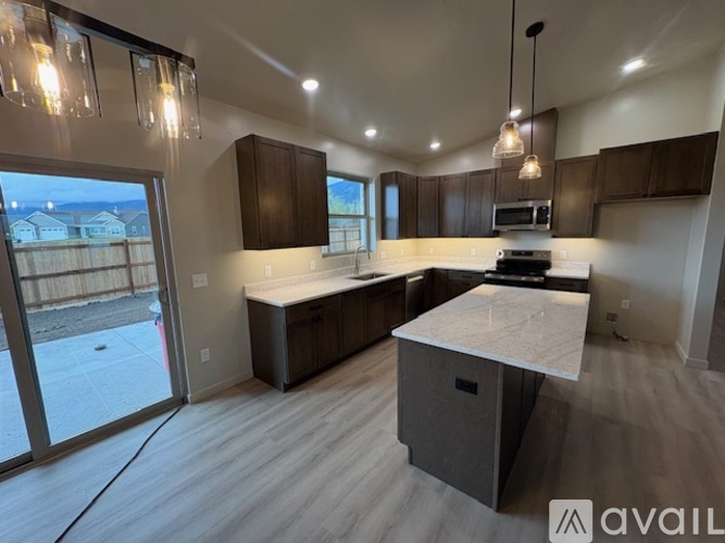 A modern kitchen with dark brown cabinets and a large island.