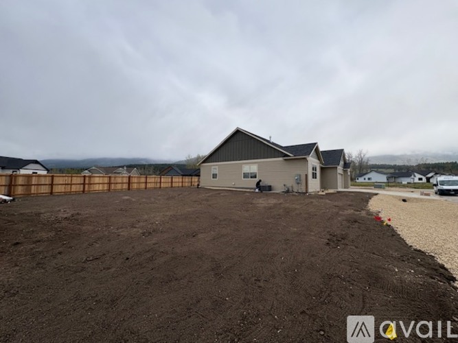 A construction site with a building and a fence in the background.