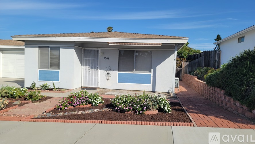 A house with a white exterior and a blue window is for sale.