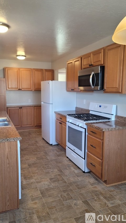 A kitchen with wooden cabinets and white appliances.