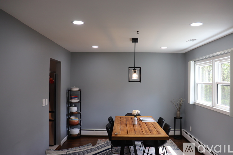 A dining room with a wooden table and chairs.