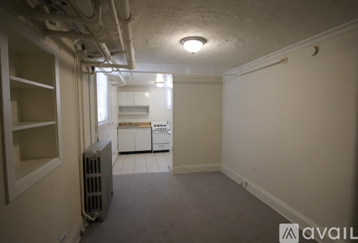 A small, empty room with a window and a radiator.