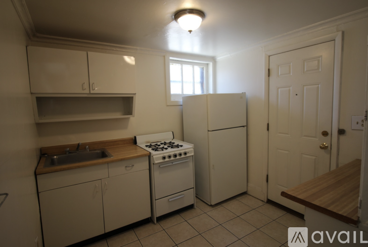 A kitchen with a stove, sink, and cabinets.