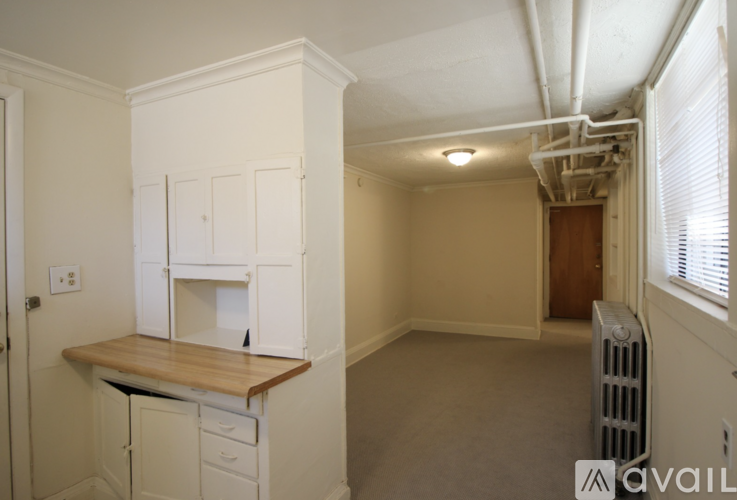 A kitchen with white cabinets and a wooden countertop.