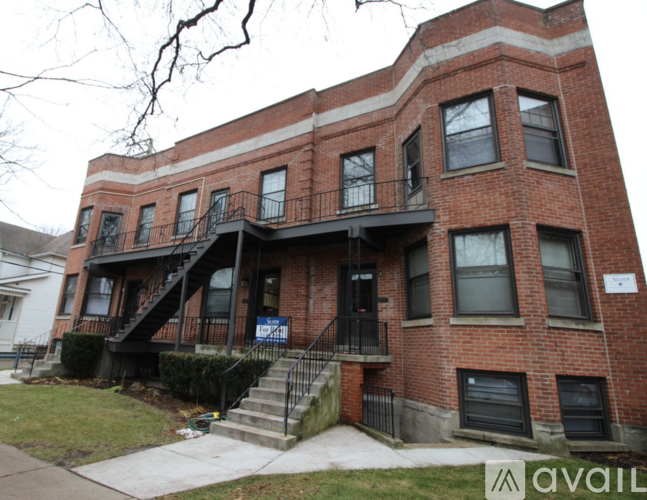 A red brick building with a balcony on the second floor.