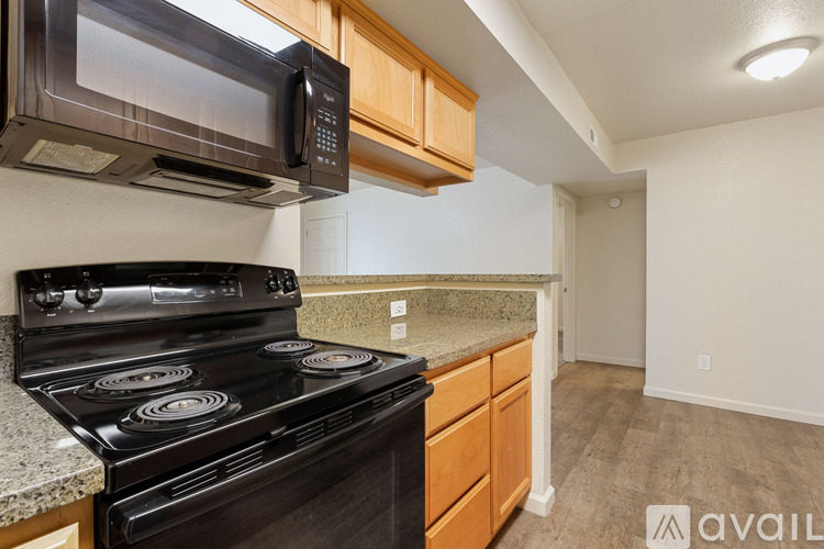 A black stove and microwave in a kitchen with wooden cabinets.