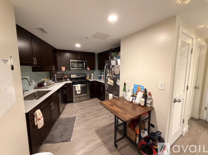 A kitchen with dark wood cabinets and a white countertop.