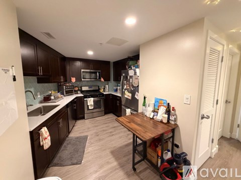 A kitchen with dark wood cabinets and a white countertop.