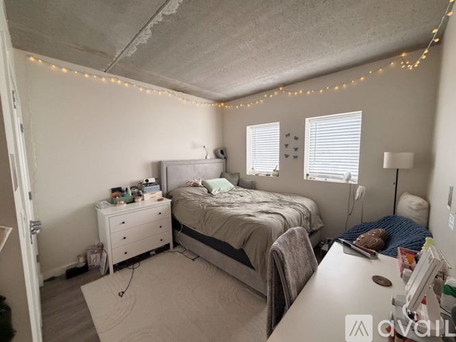 A bedroom with a bed, nightstand, and chair.
