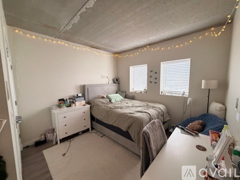A bedroom with a bed, nightstand, and chair.