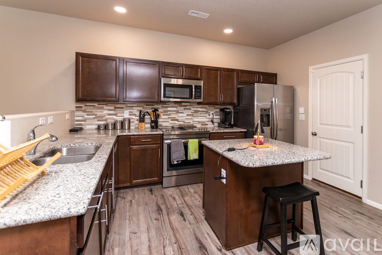 A kitchen with brown cabinets and a granite countertop.