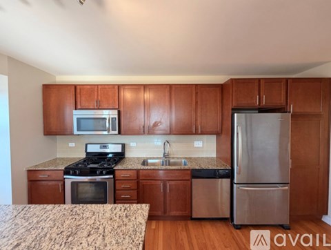 A kitchen with wooden cabinets and a granite countertop.