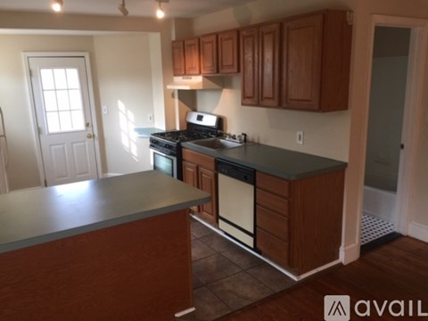 A kitchen with wooden cabinets and a black stove top oven.
