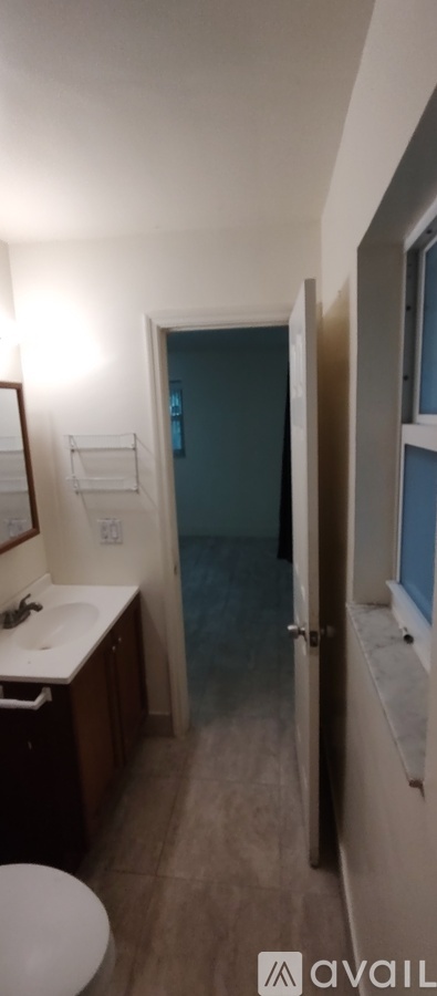 A bathroom with a toilet, sink, and mirror.