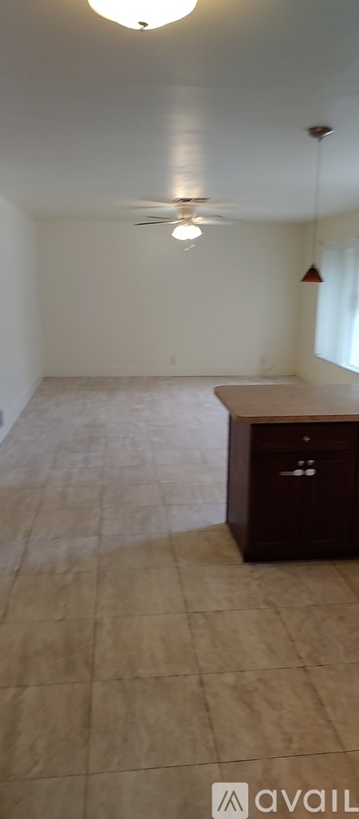 A room with a ceiling fan and a cabinet.