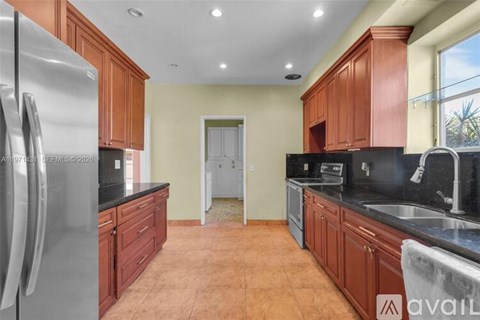 A kitchen with wooden cabinets and a stainless steel refrigerator.