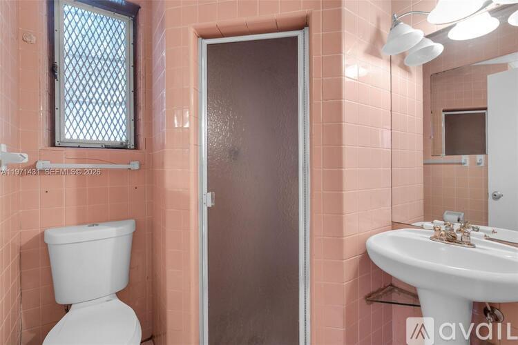 A bathroom with pink walls, a white toilet, and a white sink.