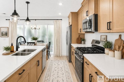 A kitchen with wooden cabinets and a black stove top.