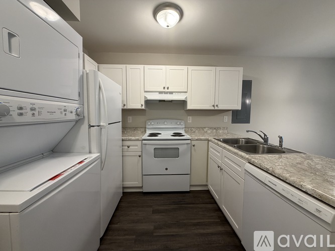 A kitchen with white appliances and cabinets.