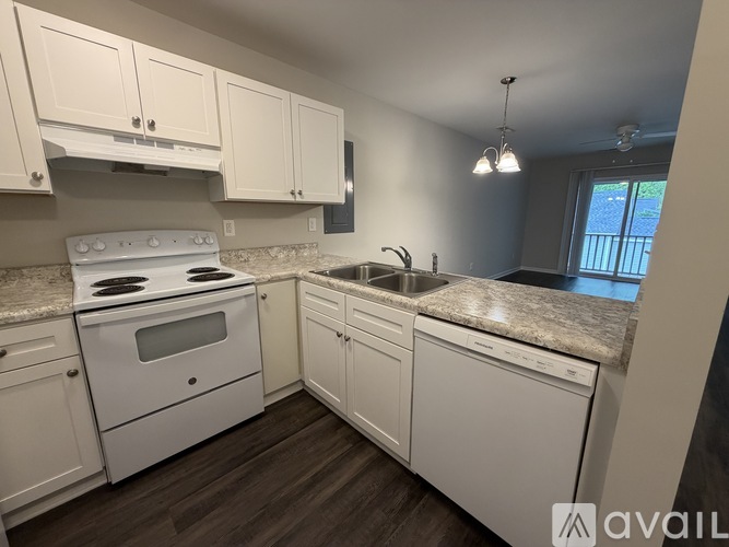 A kitchen with white appliances and cabinets.