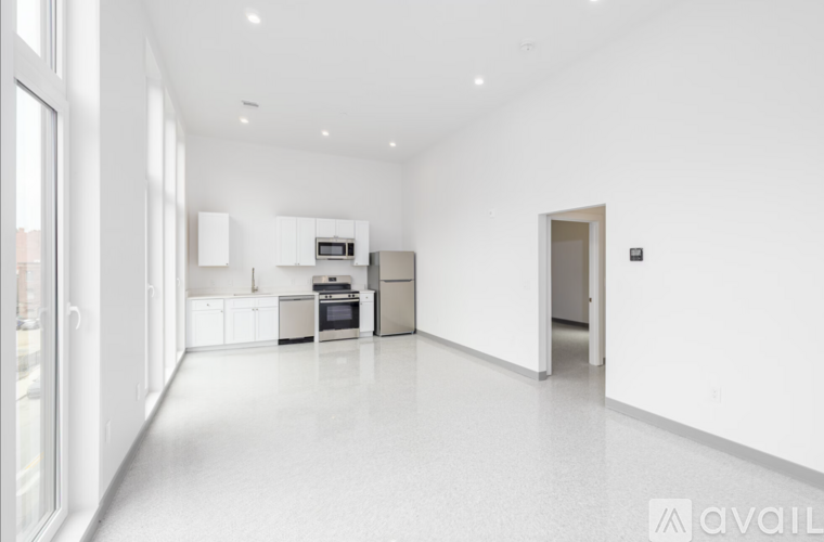 A spacious kitchen with white appliances and cabinets.