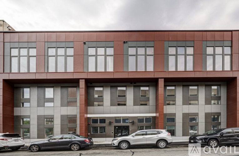 A multi-story building with cars parked in front.