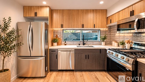 A modern kitchen with wooden cabinets and stainless steel appliances.