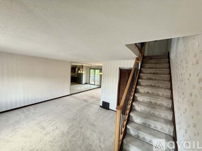 A room with a staircase leading to another room.