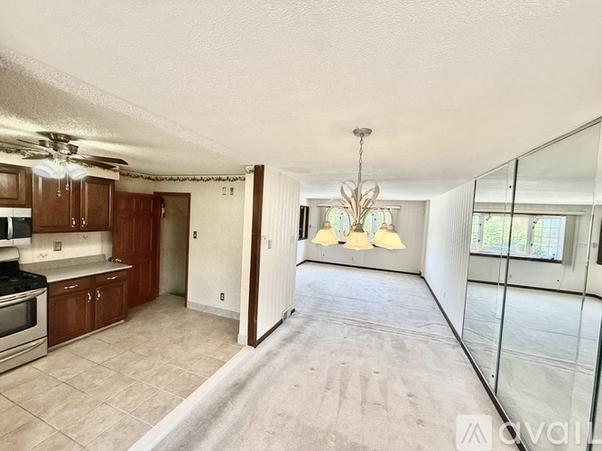 A spacious living room with a kitchen area and a dining table.