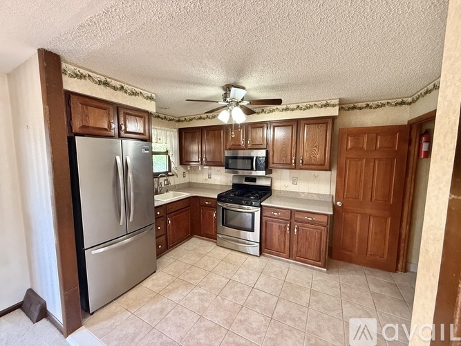 A kitchen with a refrigerator, stove, and microwave.