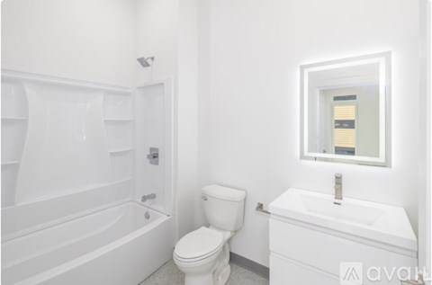 A white bathroom with a toilet, sink, and bathtub.