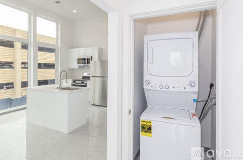 A white fridge is in a kitchen with a white island.