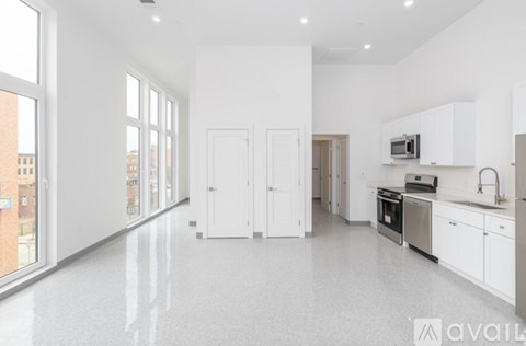 A spacious kitchen with white cabinets and appliances.