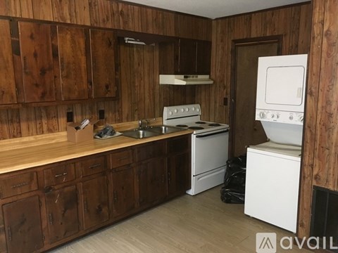 A kitchen with wooden cabinets and a white oven.