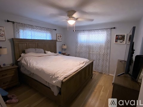 A bedroom with a bed, nightstand, and television.