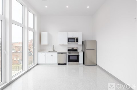 A white kitchen with a refrigerator, oven, and microwave.